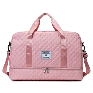 Pink quilted travel duffle bag detail with logo patch and bottom compartment