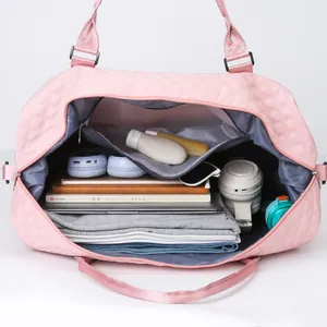 Detail of pink quilted duffel bag showing spacious interior with clothes and laptop.