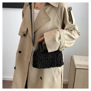 Chic black plush square handbag shown on a model wearing a tan stylish trench coat.
