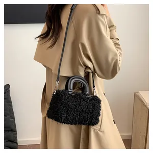 Detailed shot of black fuzzy shearling crossbody bag styled with a classic khaki trench coat