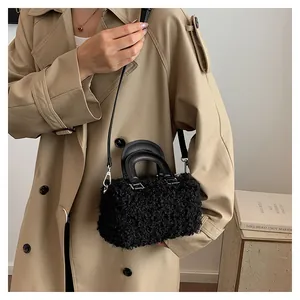 Stylish black fuzzy rectangular handbag shown in a lifestyle view with a beige coat.