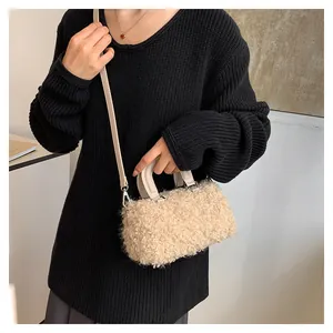 Close-up of beige plush faux fur square handbag with silver hardware and shoulder strap