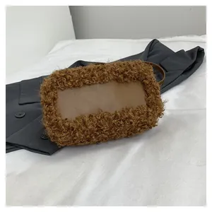 Close-up of the brown teddy fur and leather rectangular crossbody bag on a blazer.