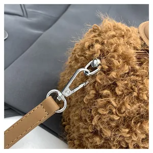 Close-up detail of the durable silver metal clasp and strap on a brown plush fuzzy handbag.