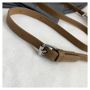 Close-up detail of the adjustable brown leather strap with silver metal buckle