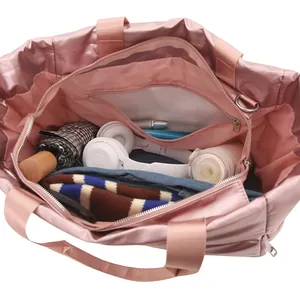 Large capacity pink travel tote bag showing spacious interior with storage pockets and items