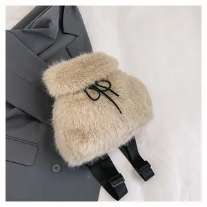 Detailed view of a stylish soft beige faux fur backpack with black drawstring closure.