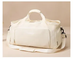 Detailed view of cream-colored duffel bag with handles and adjustable shoulder strap