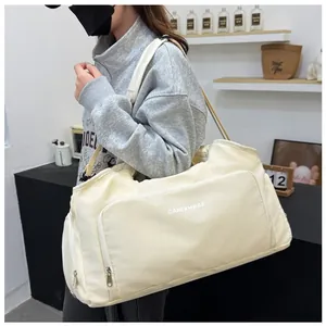 Large cream capacity travel duffel bag shown on the shoulder in a lifestyle setting