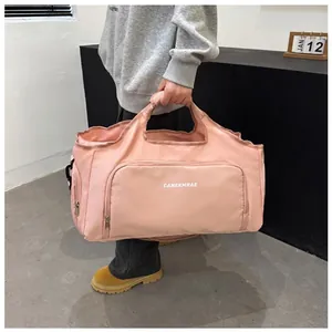 Stylish pink large capacity travel duffel bag shown in a lifestyle setting for gym or trips