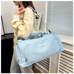 Light blue large capacity travel duffel bag shown on shoulder in a modern room setting