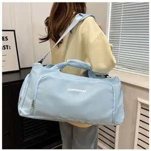 Light blue large capacity travel duffel bag carried by model for sports and gym use.
