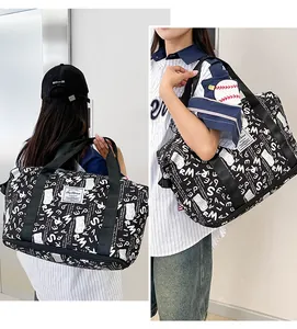 Vista detallada de bolsa de viaje con estampado de letras llevada por modelo.