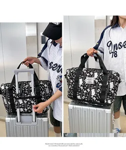 Detalle que muestra el bolso de viaje fijado al asa de un trolley de maleta plateada