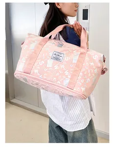 Vista detallada de bolsa de viaje rosa con estampado de letras llevada por modelo.