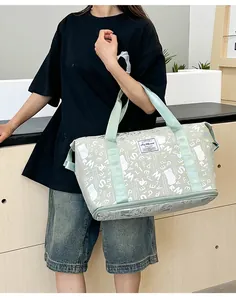 Bolsa de viaje grande verde menta con estampado de letras blancas llevada por modelo