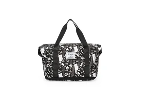 Vista frontal de un bolso de viaje negro con patrones de graffiti blancos y asas superiores.