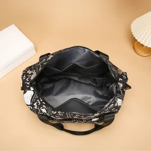 Bolsa de viaje negra con estampado de letras y bolsillos internos para separación