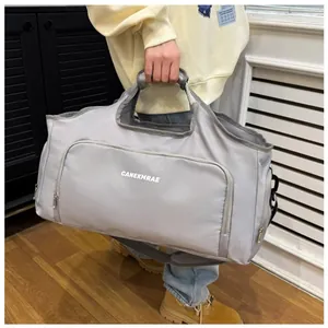 Detailed view of the spacious silver travel bag with sturdy handles and shoulder strap.