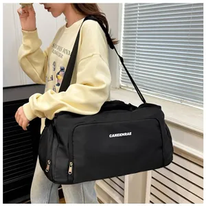 Large capacity black travel bag with shoulder strap shown being carried by a model