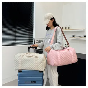 Lifestyle shot of quilted pink and cream travel duffle bags for fitness and trips