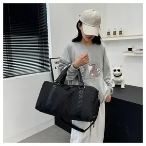 Large black quilted travel bag shown carried by a model in a modern lifestyle setting