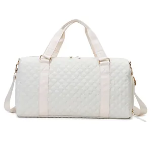 White quilted travel duffel bag with gold-tone hardware and adjustable shoulder strap