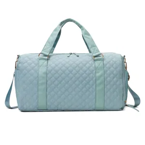 Front view of a quilted light blue fitness and travel bag featuring gold hardware details