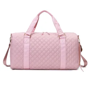 Detailed view of a pink quilted travel duffle bag with durable nylon material.