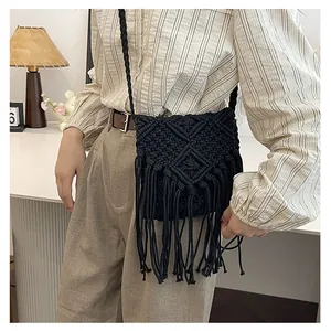 Detail showing the intricate woven pattern and long fringe of this black macramé bag