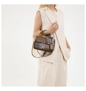 Detailansicht einer Handtasche mit Leopardenmuster und Farblock, von einem Model getragen