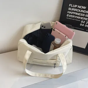 Detail view of a cream nylon gym bag showing large interior capacity for tablets and gear.