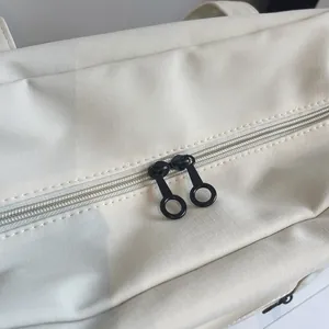 Macro detail of high-quality black double circular zipper on cream nylon travel tote bag