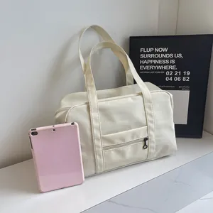Cream nylon travel bag detail with pink tablet for size comparison