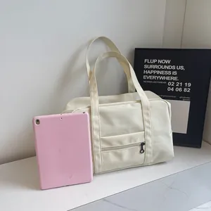 Large capacity off-white nylon tote bag shown next to a pink tablet for scale comparison.
