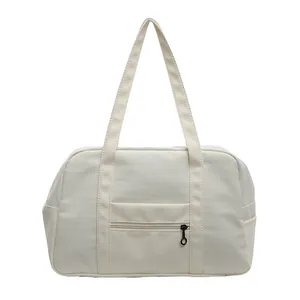 Detailed view of cream nylon tote bag featuring front zipper pocket and shoulder straps