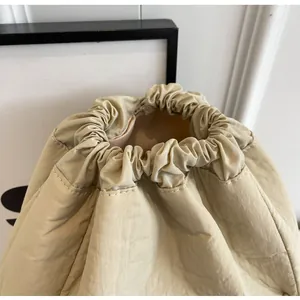 Close-up of nylon drawstring closure and fine stitching on minimalist bucket bag
