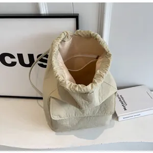 Detail of beige nylon drawstring backpack showing spacious interior and inner zip pocket