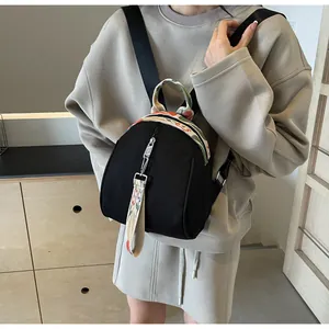 Petit sac à dos noir en forme de coquillage pour femme, idéal pour les voyages et sorties.