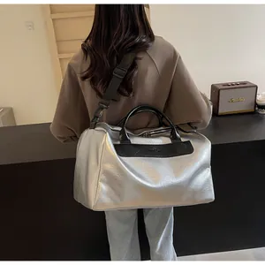 Elegante bolsa de viaje plateada con asas negras y correa de hombro ajustable, gran