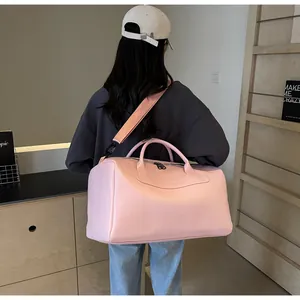 Bolso de viaje rosa grande de cuero sintético para gimnasio llevado por una modelo