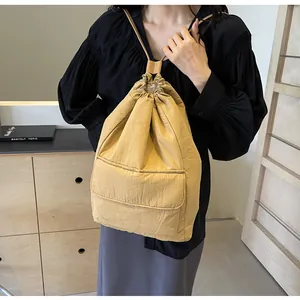 Detailed view of a lightweight khaki nylon drawstring bucket backpack on a model
