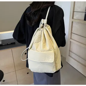Detailed view of a lightweight cream drawstring nylon backpack with front pocket