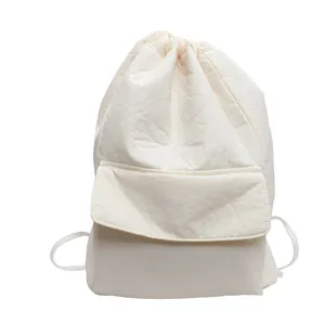 Close-up of white nylon drawstring backpack with front flap pocket and textured fabric