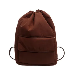 Detailed view of brown nylon drawstring backpack with large capacity and front pocket