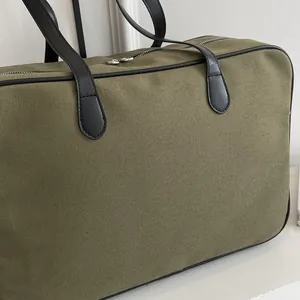 Detail einer robusten armee-grünen Canvas-Tasche mit schwarzen Trägern und Nähten
