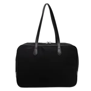 Detailansicht einer minimalistischen schwarzen Canvas-Pendeltasche mit Ledergriffen