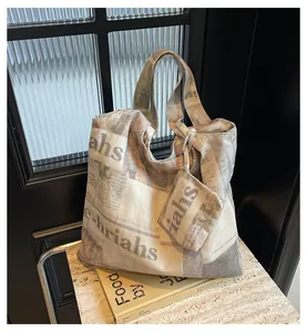 Detail view of a large canvas tote bag with a stylish and trendy newspaper print design