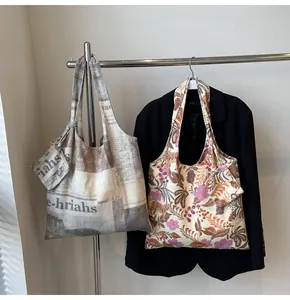 Stylish canvas tote bags with newspaper and floral prints on a clothes rack display