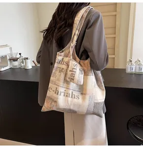 Detail view of large capacity printed canvas tote bag on model in stylish cafe setting